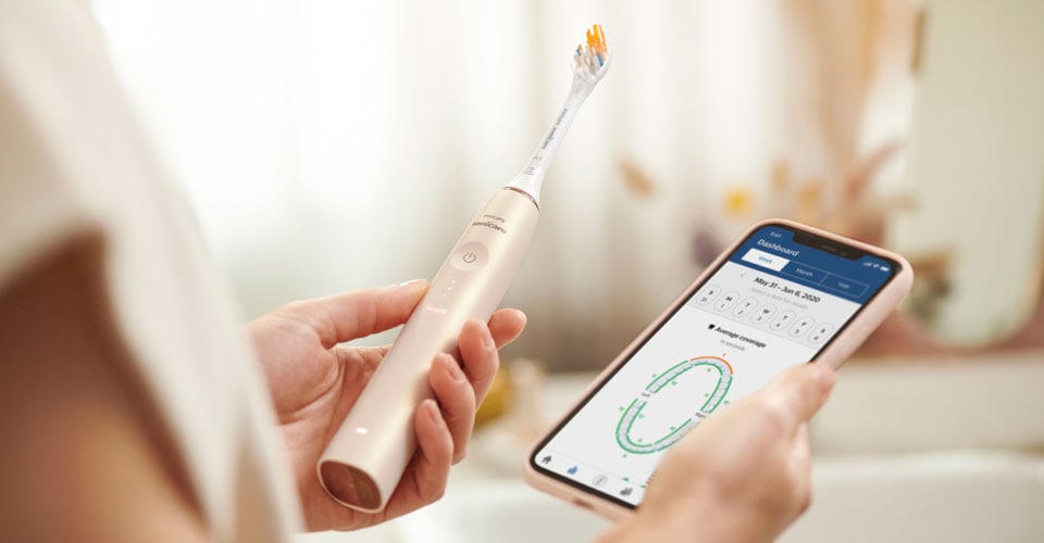 A person using the Philips Sonicare toothbrush with smart app.
